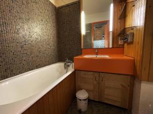 uma casa de banho com uma banheira e um lavatório e uma banheira em Studio Les Menuires, 1 pièce, 2 personnes - FR-1-452-51 em Les Menuires