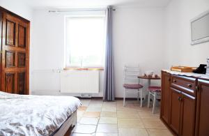 1 dormitorio con 1 cama y cocina con ventana en NiczonówNo1, en Karnitz