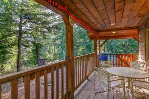 a wooden deck with a table and chairs on it at Forested Coffman Cove Cabin with Wood-Burning Stove! in Coffman Cove