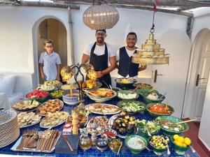 Tre uomini in piedi davanti a un tavolo di cibo di Dar Nour a Tangeri