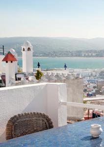 uma mesa e cadeiras numa varanda com vista para o oceano em Dar Nour em Tânger