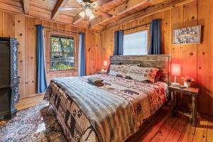 1 dormitorio con 1 cama y chimenea en una cabaña en New Listing! Cabin Fever - Hot Tub, Game Room, 3 King Beds, en Dahlonega