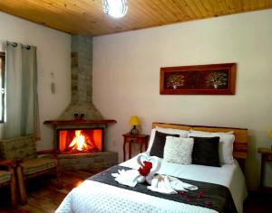a bedroom with a bed with a fireplace and a bed sidx sidx sidx at Recanto KAIRÓS in Visconde De Maua