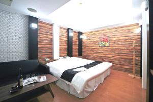 名古屋市にあるホテルLALA港店の大きなベッドと木製の壁が備わるベッドルーム1室が備わります。