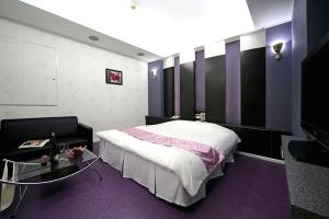 名古屋市にあるホテルLALA港店のベッドルーム1室(ベッド1台、ガラス張りのテーブル付)