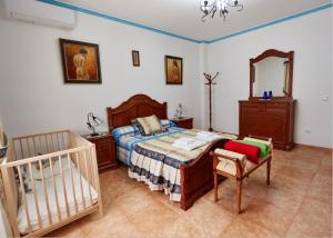 - une chambre avec un lit, un miroir et un lit bébé dans l'établissement Casa Mártires, à Iznájar