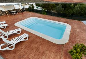 - une piscine avec 2 chaises longues et 2 chaises longues dans l'établissement Casa Mártires, à Iznájar