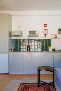 eine Küche mit weißen Schränken und einem Tisch im Zimmer in der Unterkunft O Quinto Esquerdo in Lissabon