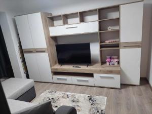 a living room with a tv in a white entertainment center at Fresh Apartman in Târgu-Mureş