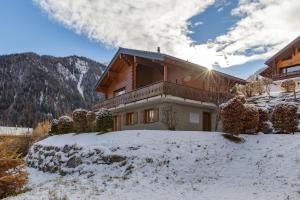 a house in the snow in front of a mountain at Chalet Elbaz - Swiss Chalet with breathtaking views in La Tzoumaz