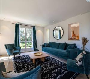 uma sala de estar com um sofá azul e cadeiras em Calm villa with swimming pool & garden, within easy walking distance to village em Tourrettes-sur-Loup
