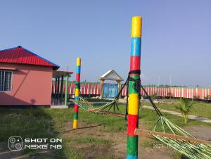 un grupo de coloridos postes con parque infantil en Coral lagoon resort, en Jaliapāra