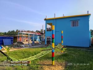 una casa con una hamaca delante en Coral lagoon resort, en Jaliapāra