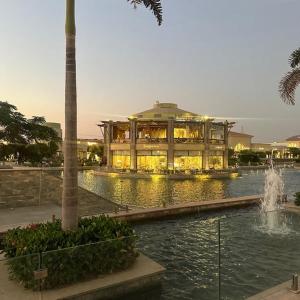 a large building with a fountain in front of a building at Grand Madinaty Couzy Home in Madinaty