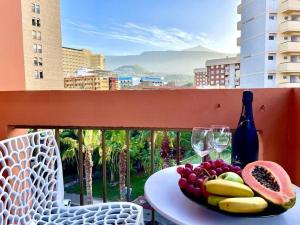 a plate of fruit and wine glasses on a table on a balcony at A piece of paradise in Puerto de la Cruz in Puerto de la Cruz