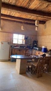 Siwa desert home في سيوة: مطبخ مع طاولة وكراسي وثلاجة