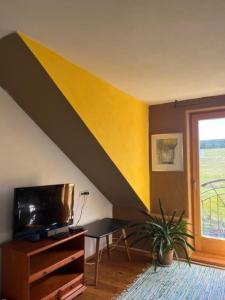 una sala de estar con una pared amarilla y negra en Haus Severin, en Fürstenfeld