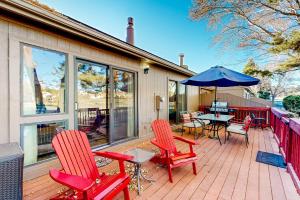 una terraza con sillas rojas y una mesa con sombrilla en Solar Serenity en Flagstaff