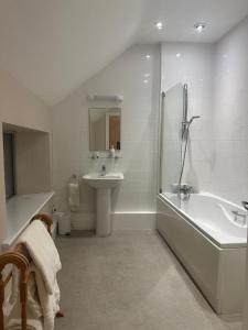 a bathroom with a tub and a sink and a bath tub at Horse and Groom Inn in Banbury