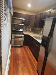 eine Küche mit braunen Schränken und einem Kühlschrank aus Edelstahl in der Unterkunft Providence Place Apartment in Providence