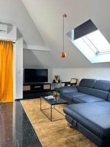 a living room with a blue couch and a tv at Luxus Penthouse Nähe Frankfurt in Bad Homburg vor der Höhe
