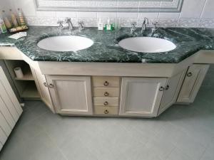 a bathroom with two sinks and a marble counter at La casa degli ulivi in Turri