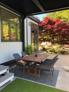 een houten tafel en stoelen op een patio bij Tiny Home Luxury Farm Escape in Egmont Village