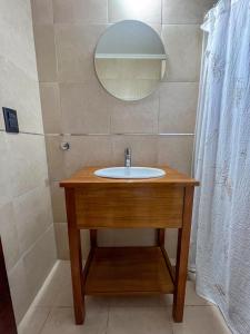 La salle de bains est pourvue d'un lavabo en bois et d'un miroir. dans l'établissement Casa quinta con entorno rural, à Chacabuco