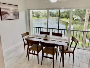 a dining room with a table and chairs and a large window at Newly remodeled 2br, 2ba condo in Naples Bath and Tennis in Naples