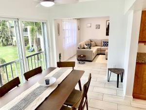 a dining room with a table and chairs and a living room at Newly remodeled 2br, 2ba condo in Naples Bath and Tennis in Naples