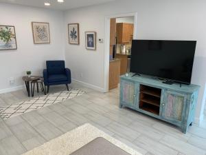 a living room with a flat screen tv on a cabinet at Newly remodeled 2br, 2ba condo in Naples Bath and Tennis in Naples