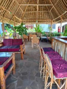 un patio con sillas, un sofá y mesas en Sea Breeze Apartments Shanzu Mombasa, en Mombasa