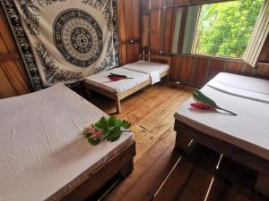 a room with three beds and a window at Capitan Morgan Homes & Tours in Pital