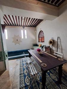 a living room with a wooden table and a couch at Pwani House - Lamu Seafront in Lamu