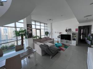 迪拜ThePenthouse Coliving II的带沙发和电视的客厅