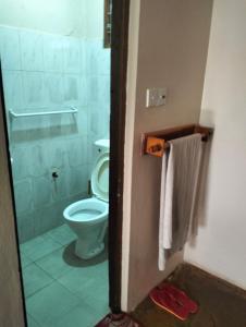 y baño con aseo, ducha y toalla. en Sea Breeze Apartments Shanzu Mombasa, en Mombasa