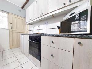 a kitchen with a microwave and a black oven at Lagoon Cabanas in Ramsgate