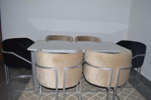 Appartement 5 etoiles agadir vue mer في أغادير: طاولة حولها أربعة كراسي مع طاولة رمادية