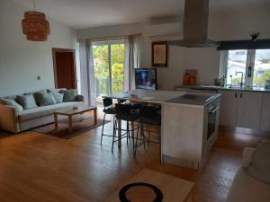 a kitchen and living room with a table and a counter at Pavlos Loft - Garden Views & Terrace in Leontari in Leondárion