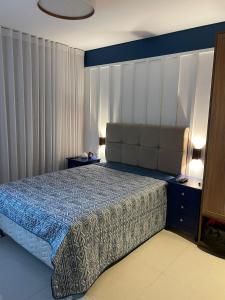 a bedroom with a bed with a blue comforter at Pé na areia - Ykutiba - Fantástico in Imbassai