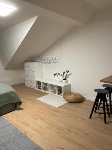 a white room with a bed and a table at Prostě Terezská in Olomouc