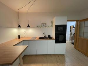 a kitchen with white cabinets and a sink at Prostě Terezská in Olomouc