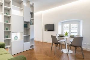 a dining room with white walls and a table and chairs at UNYCA - Duomo Luxury View Florence in Florence