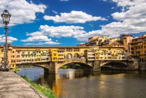 a bridge over a river in a city with buildings at UNYCA - Duomo Luxury View Florence in Florence