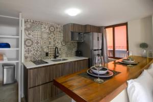 a kitchen with a wooden table with two glasses of wine at Torre Nautilus 1 in Cancún