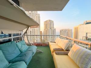 迪拜ThePenthouse Coliving II的阳台配有沙发,享有城市景观