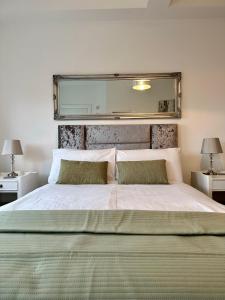 Un dormitorio con una cama grande y un espejo encima. en CC - Central Location Top Floor 2 Bed Deluxe Modern Apartment, en Stratford-upon-Avon