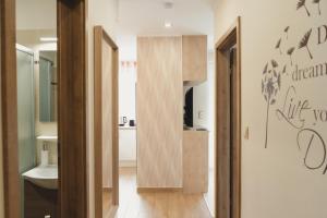 um corredor com uma porta que leva a uma casa de banho em Harmony Apartments Sárvár em Sárvár