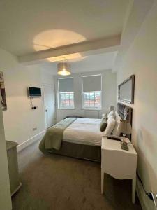 Un dormitorio con una cama y una mesa. en CC - Central Location Top Floor 2 Bed Deluxe Modern Apartment en Stratford-upon-Avon