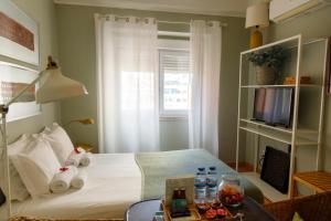 1 dormitorio con 1 cama, TV y mesa en O Quinto Esquerdo, en Lisboa